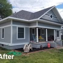 After: the same craftsman-style house repainted blue-gray with white trim